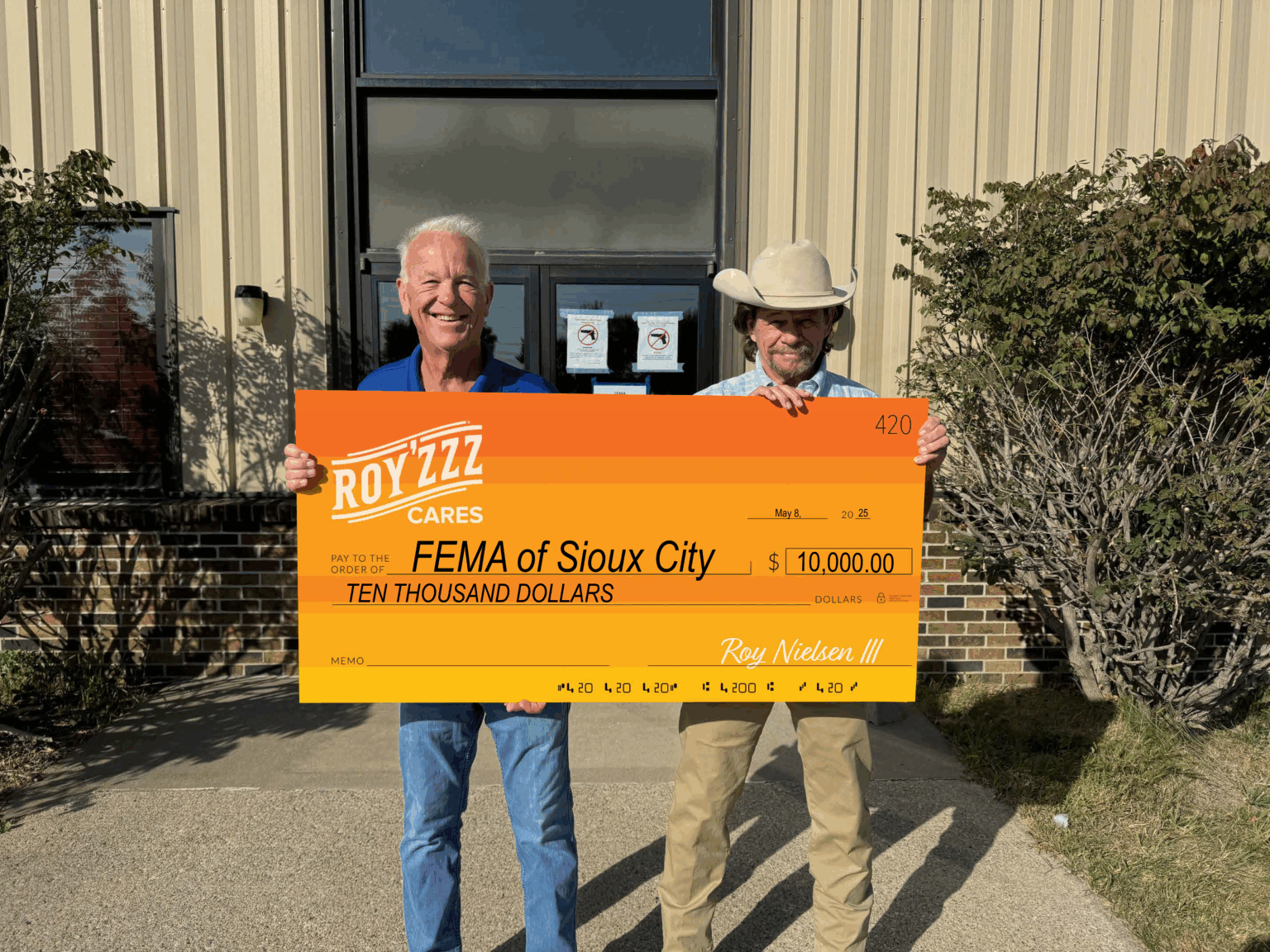 Royzzz Cares Community Nonprofit presents FEMA of Sioux City with large orange check.